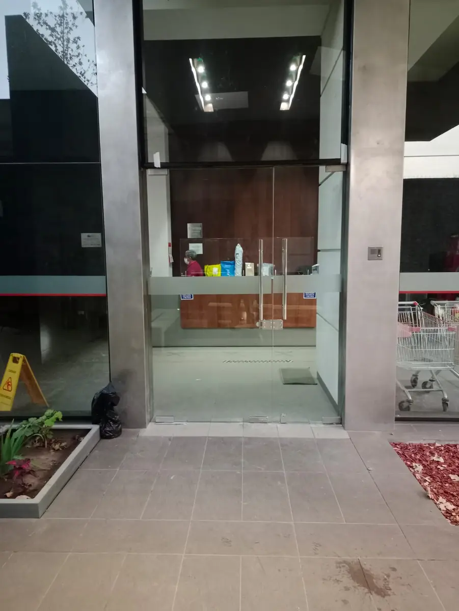 Acceso comercial con puertas y paños fijos de vidrio