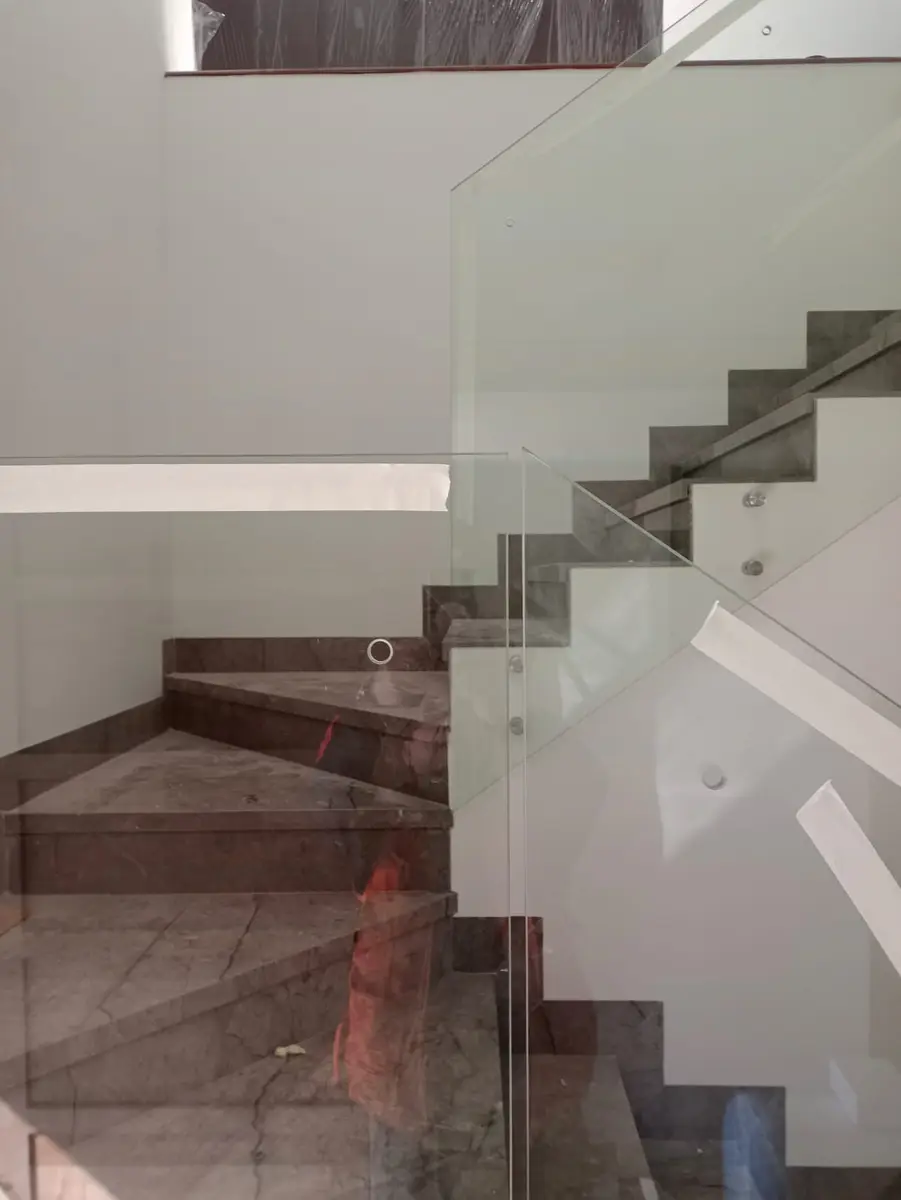 Baranda de vidrio en una escalera interior con fijaciones puntuales