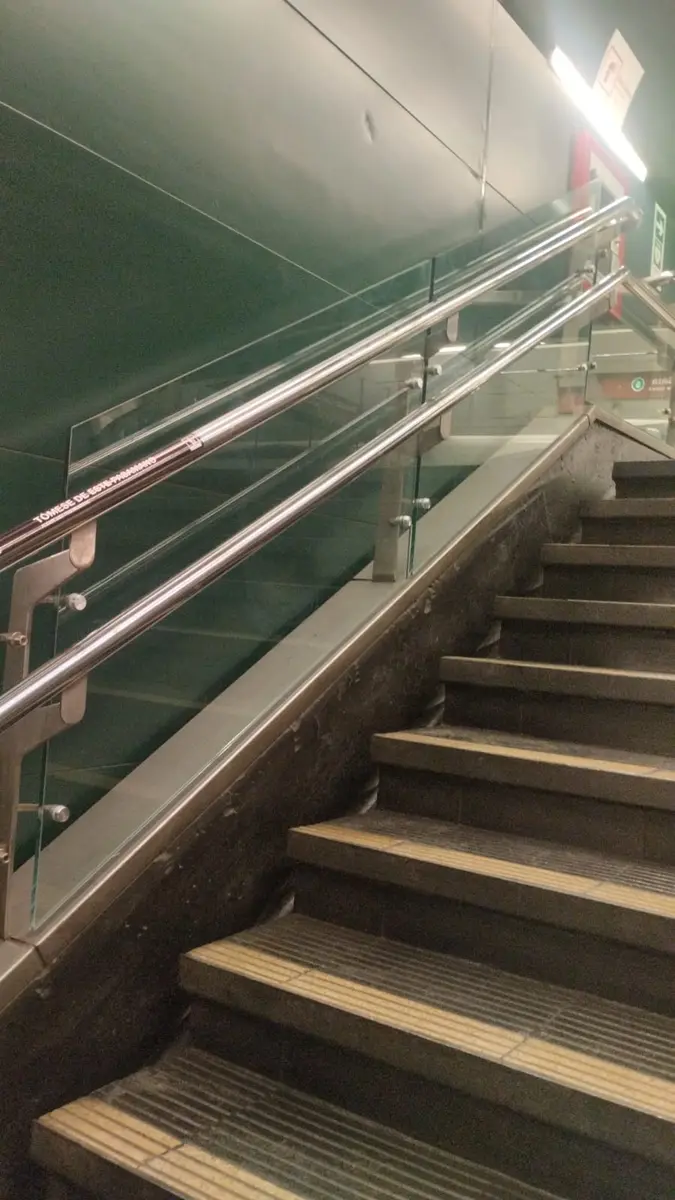 Baranda de vidrio con pasamanos de acero inoxidable en una escalera