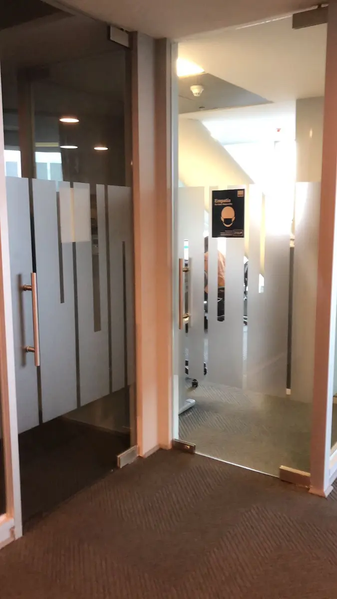 Puertas de vidrio de oficina con franjas empavonadas decorativas